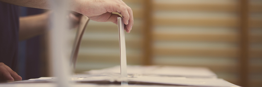 Image of a ballot being inserted into the voting box