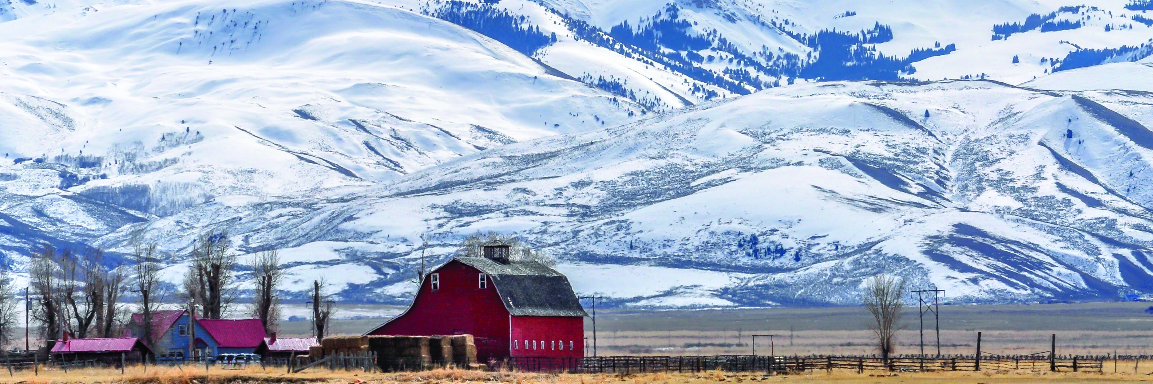red barn snow covered mountains